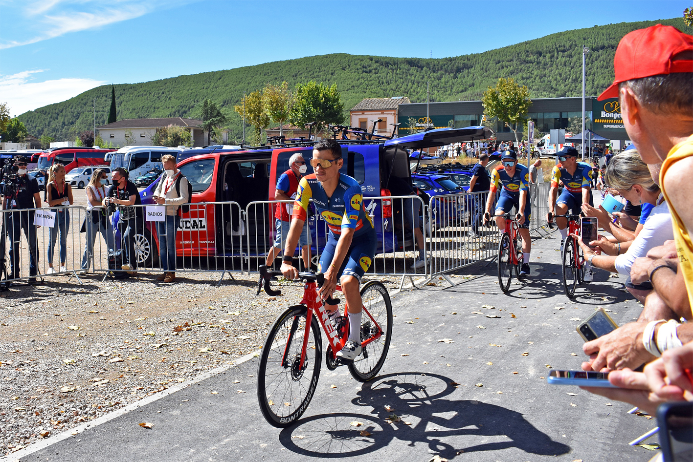 Diferents ciclistes sâ€™adrecen al punt de control de signatures de la tercera etapa de La Vuelta 2023, al Rieral del Tordell.