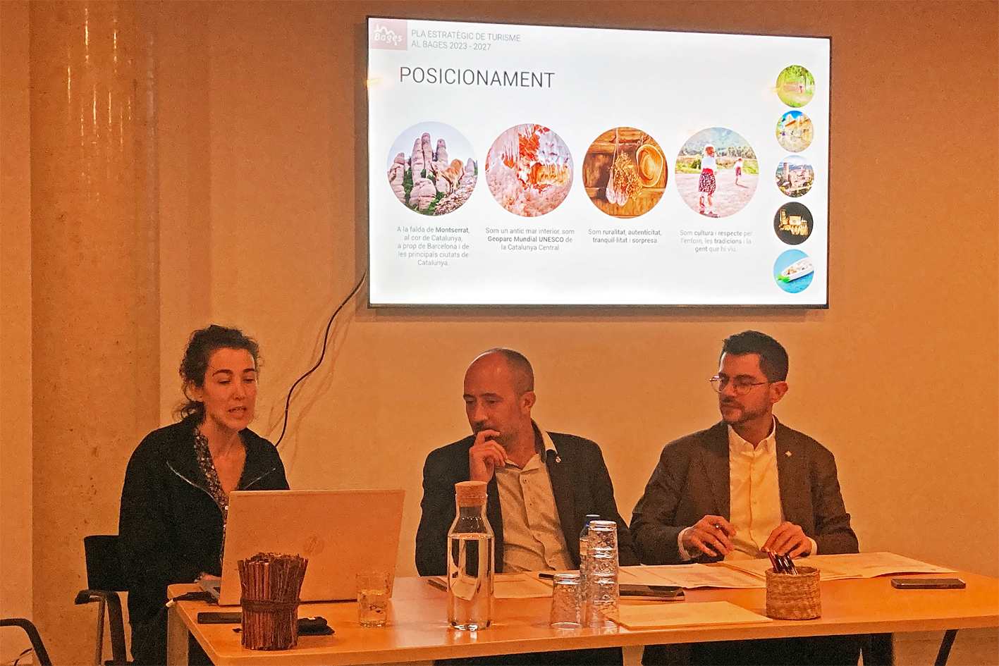 El president del Consell Comarcal del Bages, Eloi Hernàndez, i l'alcalde de Manresa, Marc Aloy, escolten la responsable de l'àrea de Turisme del Consell Comarcal, Montserrat Selga, durant el plenari de Bages Turisme a la nova Sala del Portal.