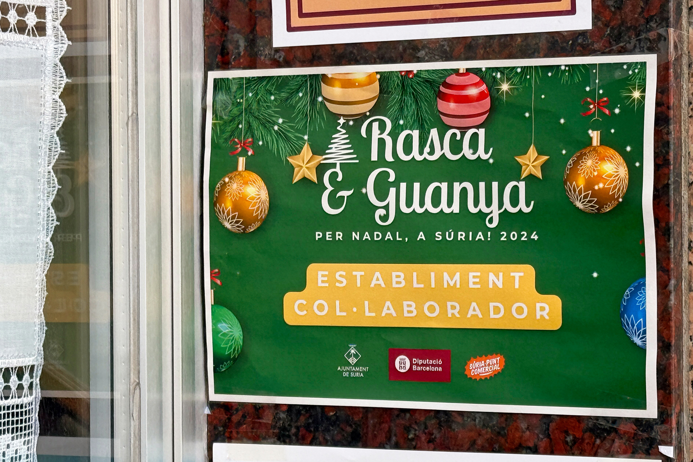 Full promocional de la campanya 'Rasca i guanya' en un establiment comercial de SÃºria.