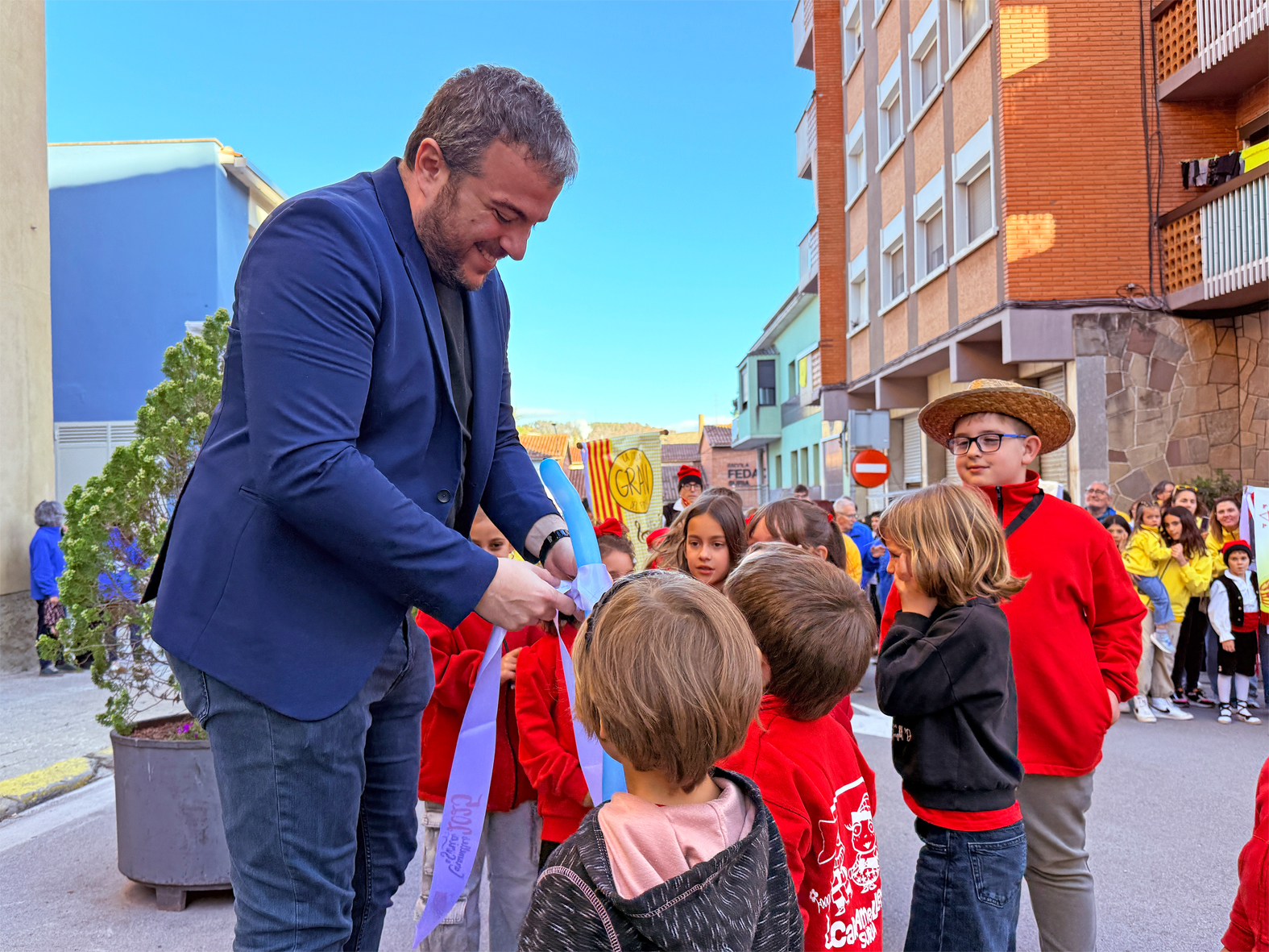 L'alcalde Albert Coberó lliura la cinta commemorativa a la colla d'Altatxets, en l'acte d'inici de les Caramelles de Súria, al davant de la Casa de la Vila.