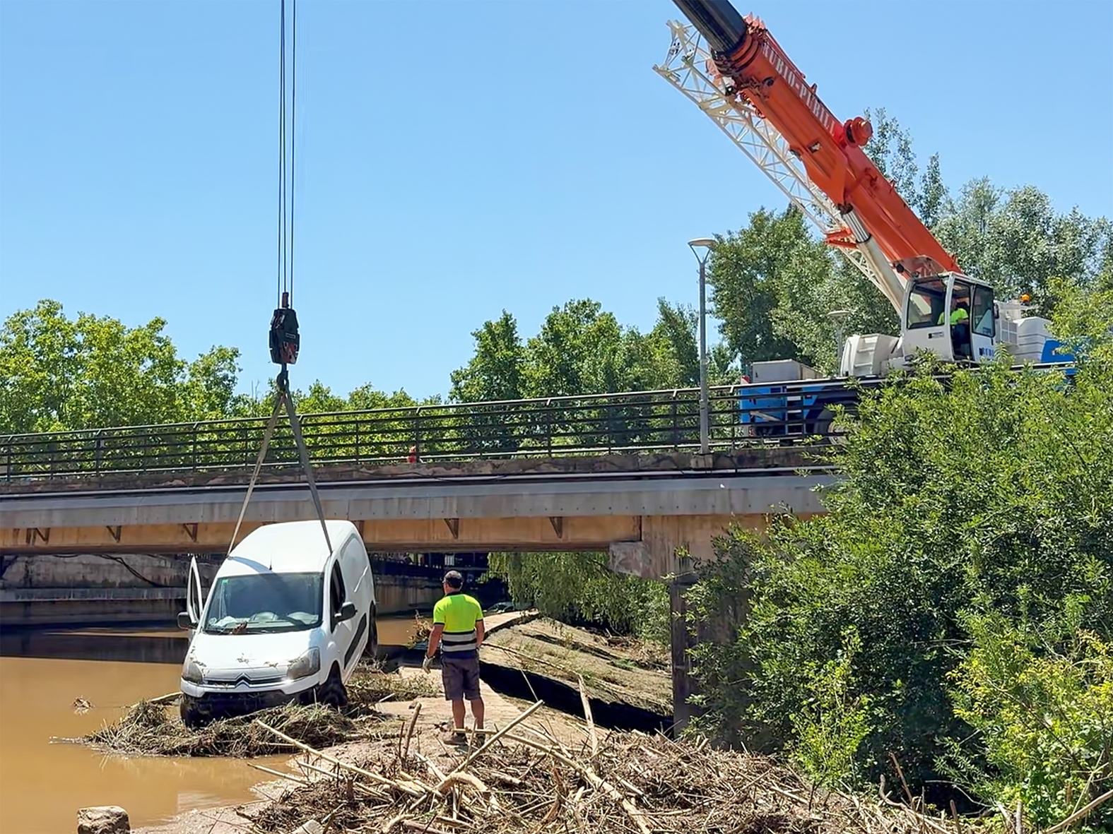 Una grua de grans proporcions retira les dues furgonetes arrossegades pel riu Cardener durant la tempesta