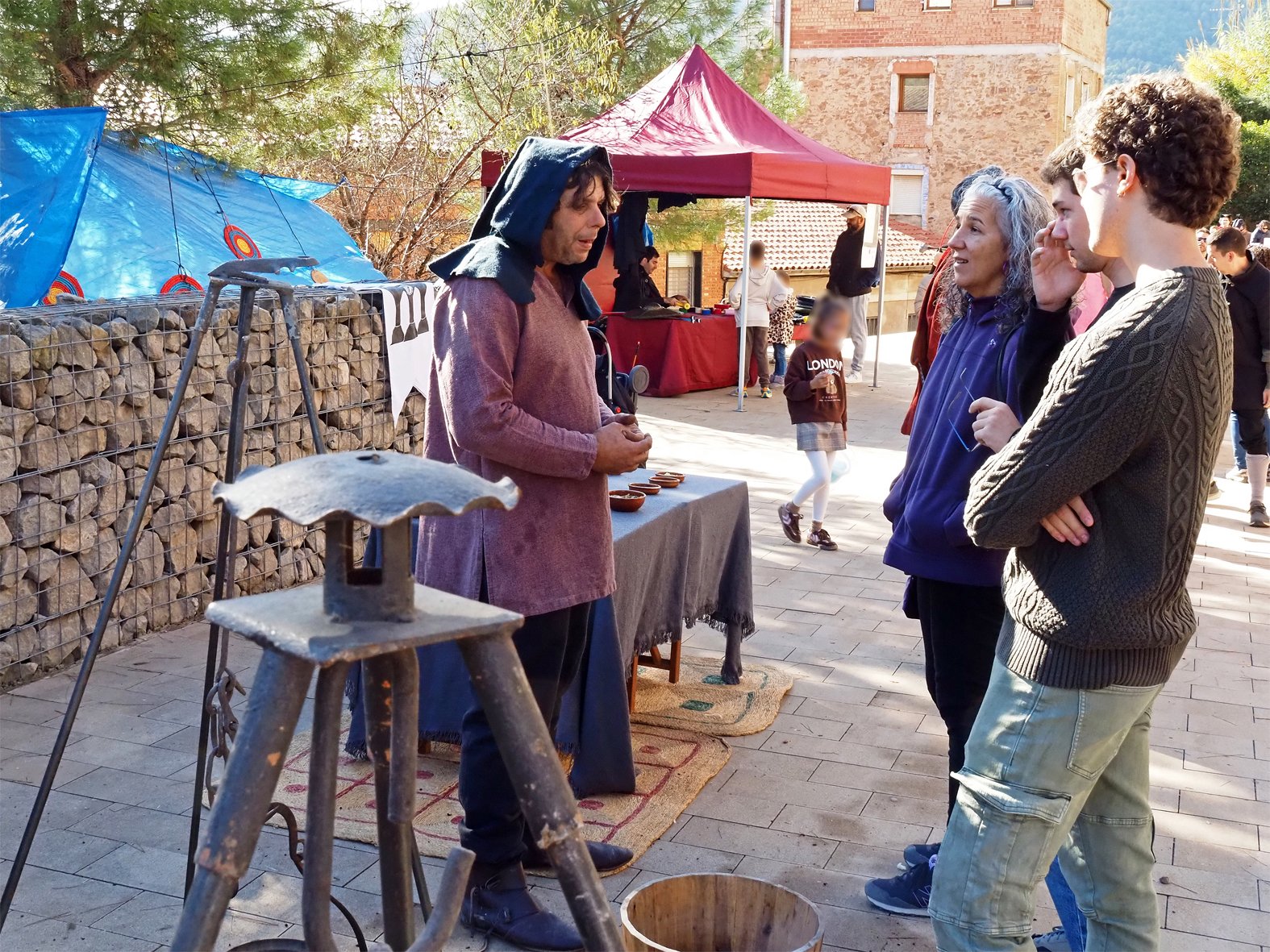 Un personatge de la 22a Fira Medieval d'Oficis de Súria parla amb visitants a l'Espai Firal dels Galàpets.