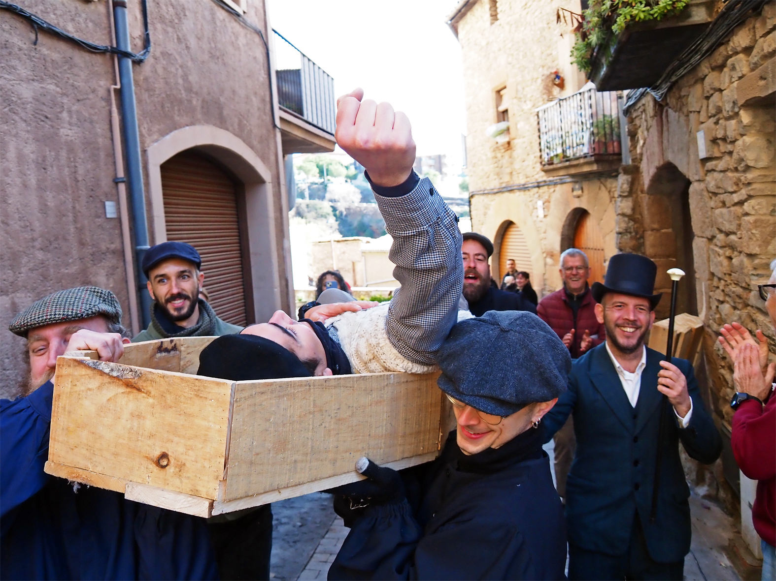 Arribada a la meta del darrer participant de la 2a Cur(s)a del C&ograve;lera, acompanyat per l'alcalde de 1885, Joan Santamaria, els enterramorts i altres persones, dins de la Festa de Sant Sebasti&agrave;.