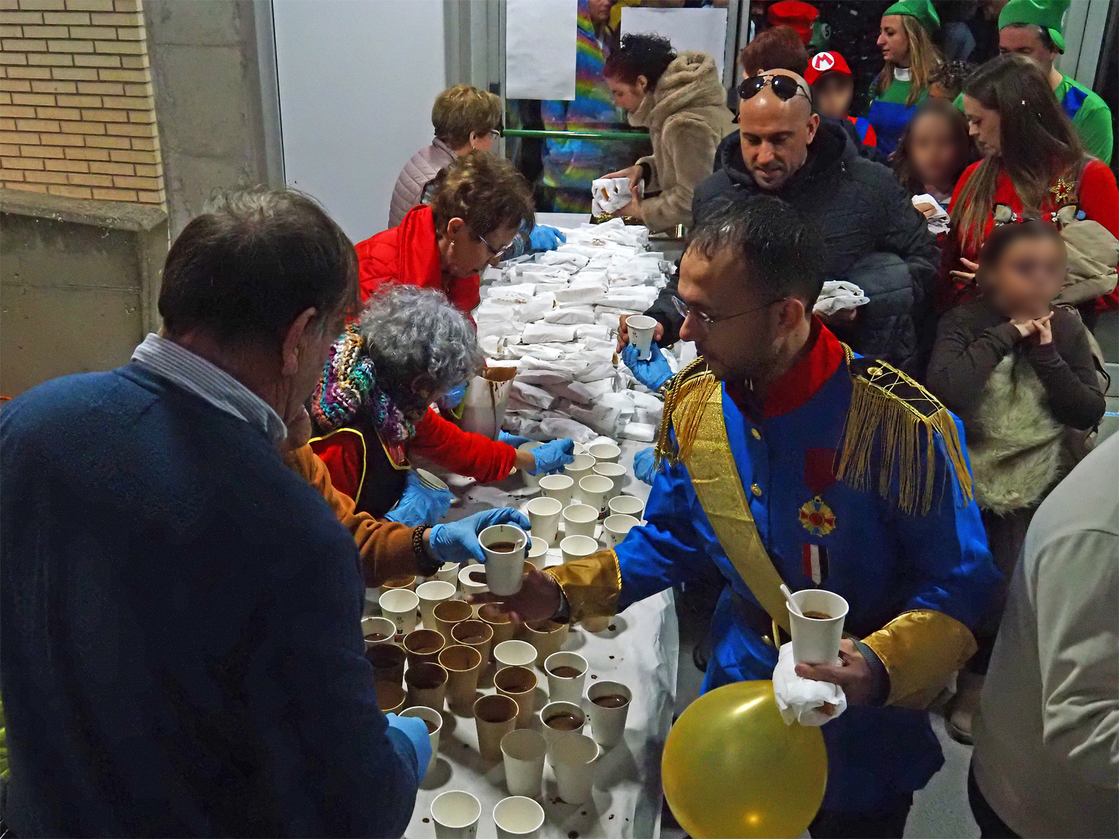 Repartiment de coca i xocolata a les persones participants en la rua del Carnestoltes de S&uacute;ria.