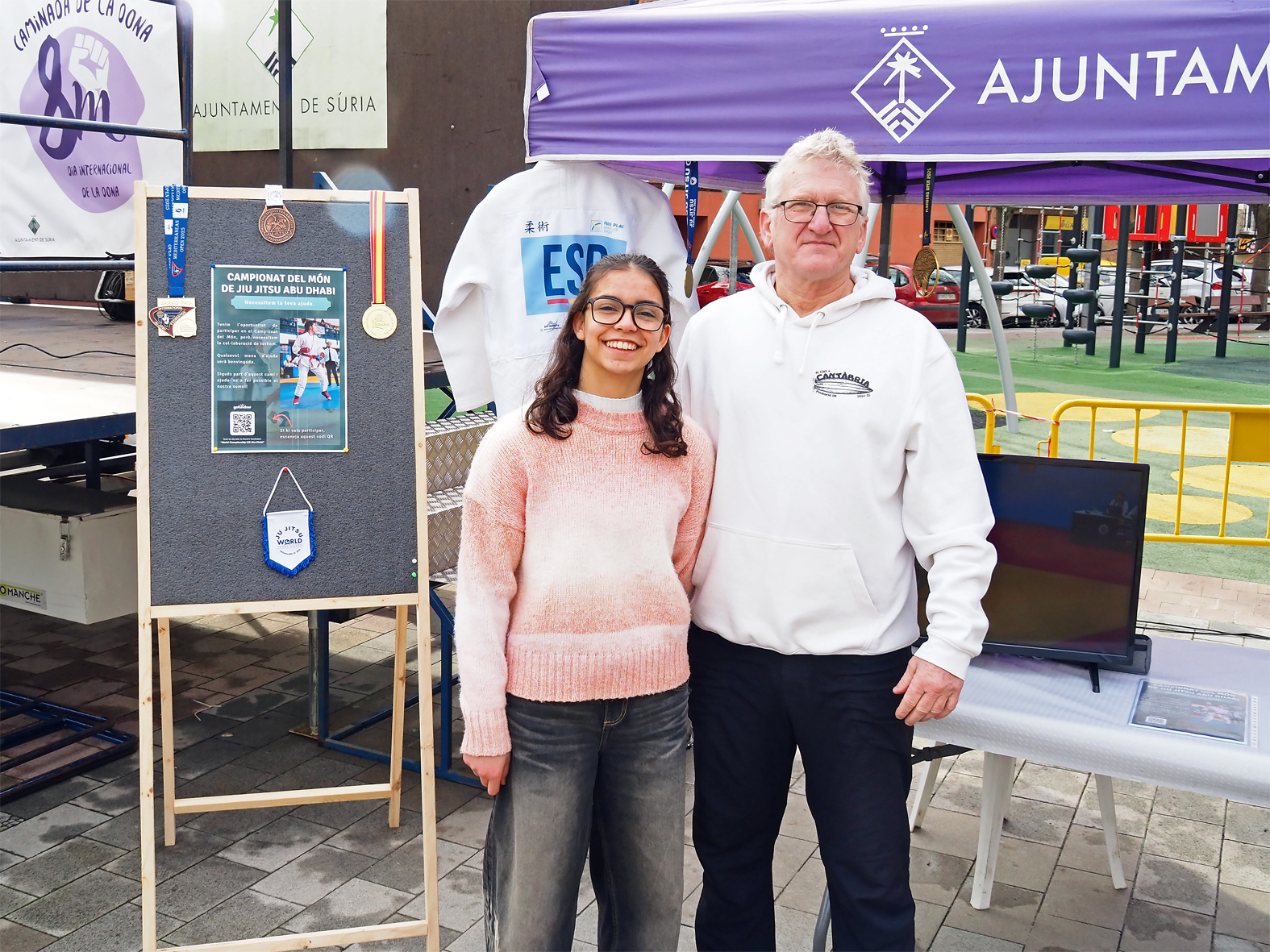 La campiona surienca de jiu jitsu, N&uacute;ria Álvarez, i el t&egrave;cnic Gaspar Gamisans, a la parada de suport instal&middot;lada a la pla&ccedil;a de Sant Joan durant la 5a Caminada de la Dona.
