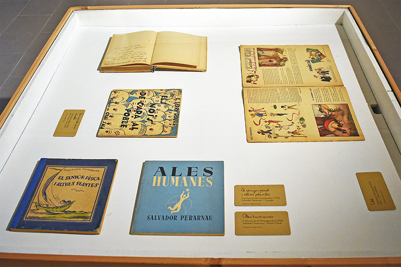 Vitrina de lâ€™exposiciÃ³ 'Contes infantils de la Guerraâ€™ a la sala Cal Balaguer del Porxo, amb diferents llibres i documents del poeta surienc Salvador Perarnau.