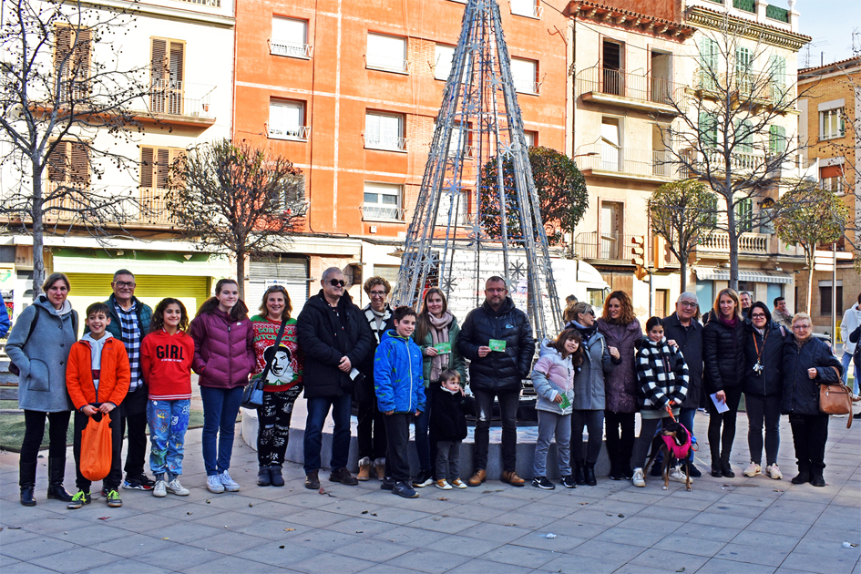 Foto de grup de les persones guanyadores del 3r concurs 'IlÂ·luminem el Nadal!â€™, a la plaÃ§a de la Serradora, amb la regidora de Festes, Alba Santamaria, dins dels actes de la Fira de Nadal i Fira dâ€™Entitats de SÃºria.