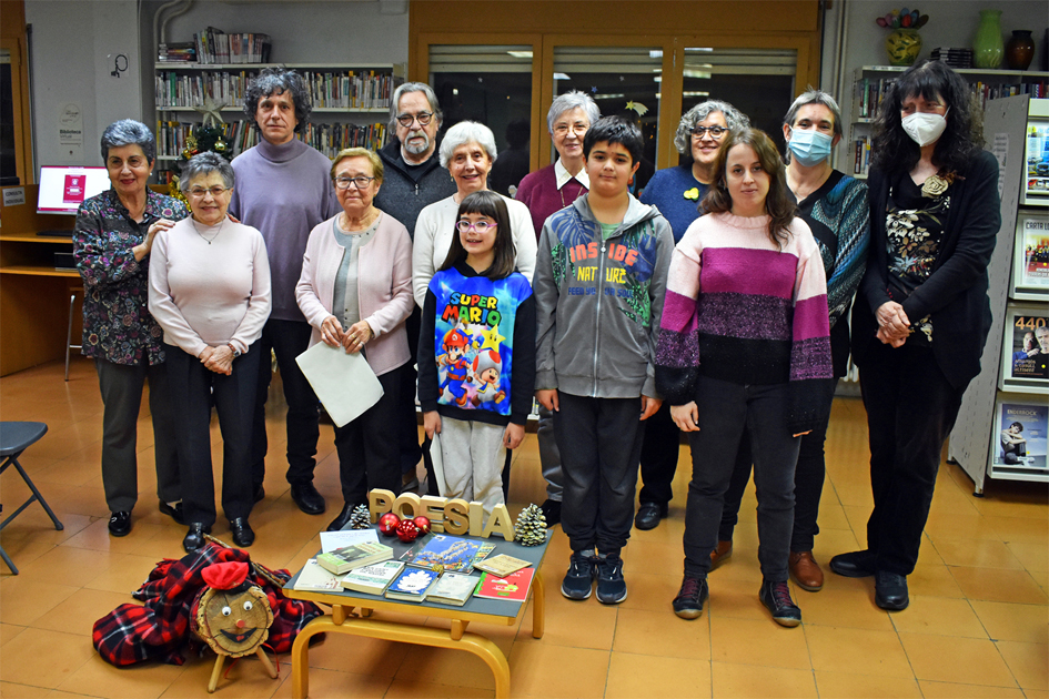 Foto de grup de les persones participants en la lectura de poemes de Nadal a la Biblioteca PÃºblica, amb el grup del Taller de Lectura de L'Esplai.